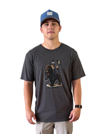 Man wearing a dark gray t-shirt with a graphic design of a bear and a cap on a white background